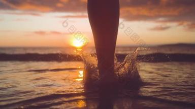 慢动作，特写，复制空间：女人慢跑者在日出时跑进清爽的海洋溅水。当女人跑进大海时，<strong>金</strong>色的阳光慢慢消失在地平线后面.